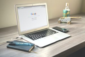 Computer on desk with google homepage displayed